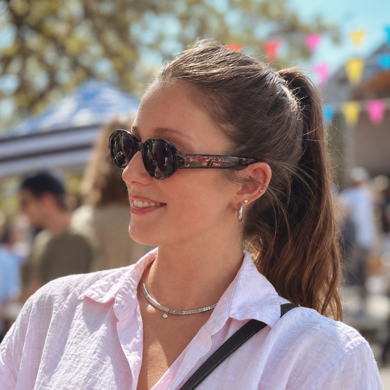 Meghan smiling outdoors in sunglasses